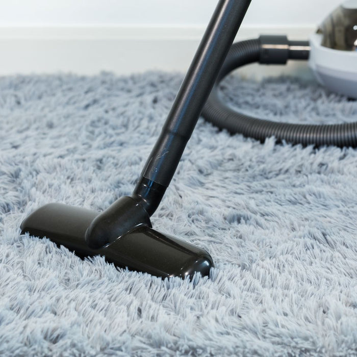 Hoovering a shaggy rug. 