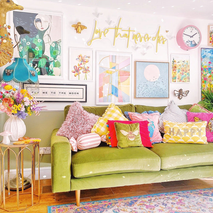 Colour living room styling the dopamine decor trend. A colourful Persian rug  features in the centre, with a bright green sofa, lots of cushions, and a wall filled with unique artwork. 