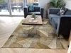 Photo By Gillian M. | Living room with a patterned rug, gray sofa, and wooden coffee table.