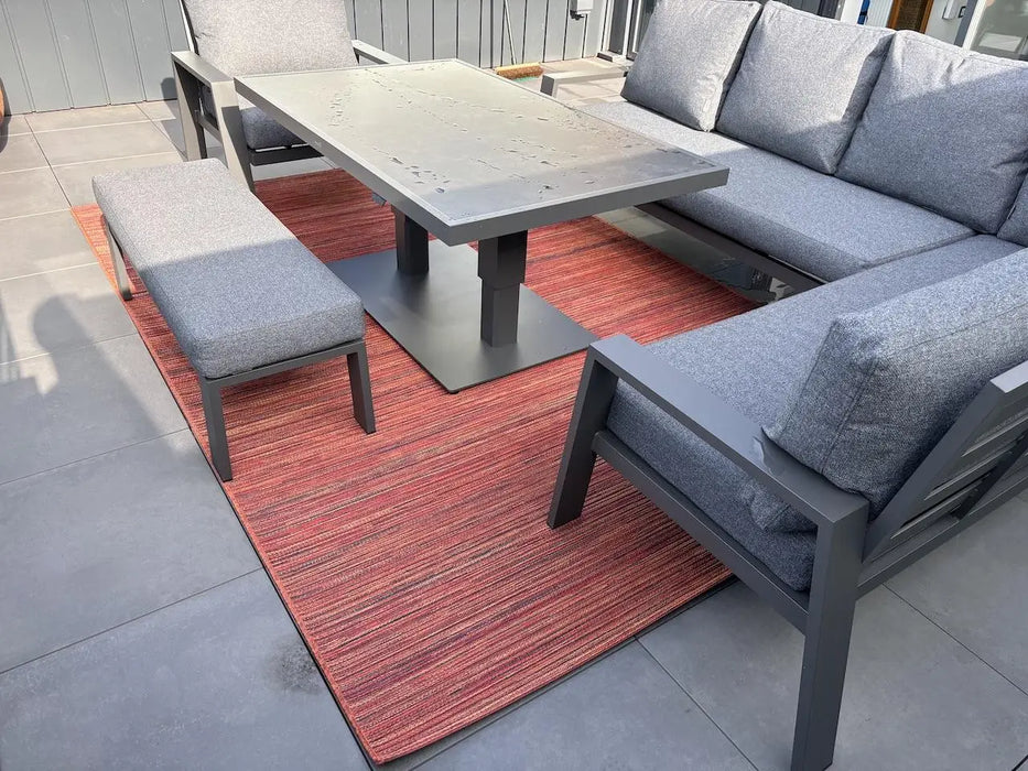 Photo by Robert G. | Outdoor patio set with gray sectional sofa, table, and bench on a red rug Bright 0122 1000