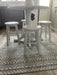 Photo By Nicola T. | White round table with three stools on a patterned rug in a kitchen.