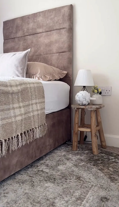 Photo by At Home with Fifi | Bedroom with a brown upholstered headboard, white bedding, and decorative items on a wooden stool.