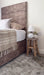 Photo by At Home with Fifi | Bedroom with a brown upholstered headboard, white bedding, and decorative items on a wooden stool.