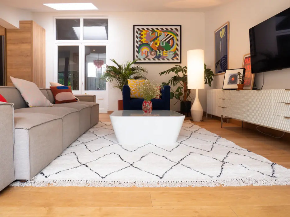 Photo By Benjy | Modern living room with a gray sofa, coffee table, and decorative elements.
