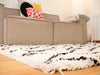 Photo by Benjy | Beige sofa with colorful cushions and a white and black textured rug on a wooden floor.