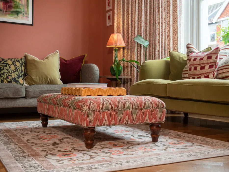 Photo By Biff | Living room with two sofas, a patterned ottoman, and decorative pillows and Paisley Rug