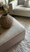 Photo By @mydreamhome_usplus6 | Beige sofa with a woven basket and decorative flowers on a carpeted floor.