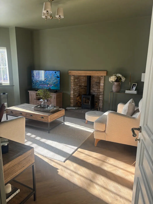 Photo by @renovatingcheshire |Living room with a fireplace, TV, and furniture.
