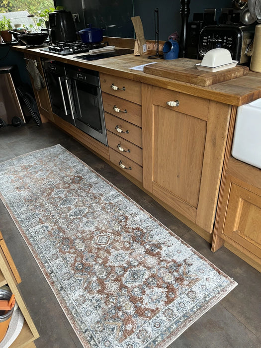 Photo By Alison W. |Kitchen with wooden cabinets, a rug on the floor, and various kitchen appliances.