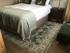 Photo By Elizabeth M. | Bedroom with a bed, nightstand, and patterned rug.