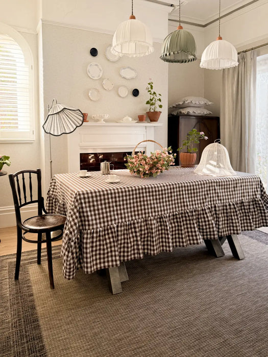 Photo By @ourvictorianhome1875 | Dining room with a checkered tablecloth, chairs, and decorative elements.